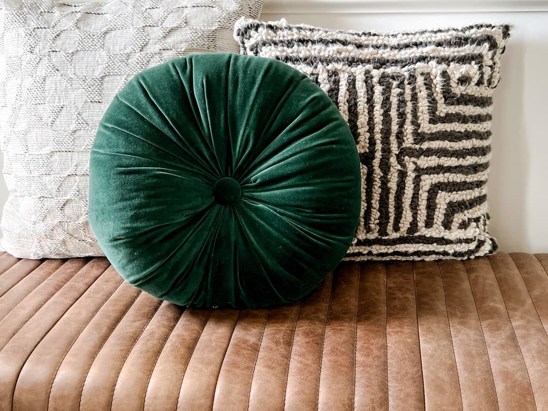 A Natassja Designs styling detail with pillows on a leather bench