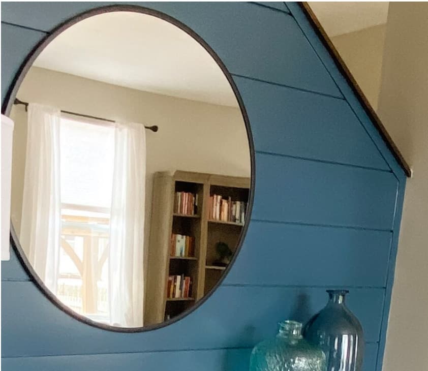 A Natassja Designs entry vignette with a round mirror and shiplap wall